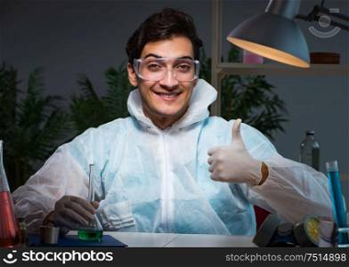 Young male lab chemist late at night in overtime time. The young male lab chemist late at night in overtime time