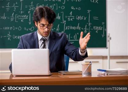 Young male math teacher in classroom 