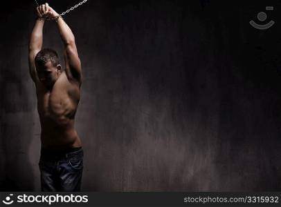 young male model well build with chains over his arms
