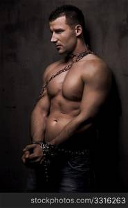 young male model well build with chains over his body