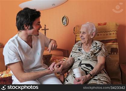 young male nurse and smiling senior woman in his bedroom