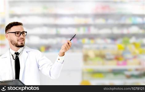 Young male pharmacist pointing at empty copy space for your text in the hospital. Medical healthcare and doctor staff service.
