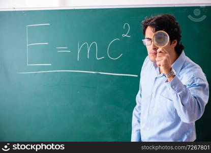 Young male physic standing in front of the green board