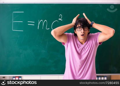 Young male physic standing in front of the green board