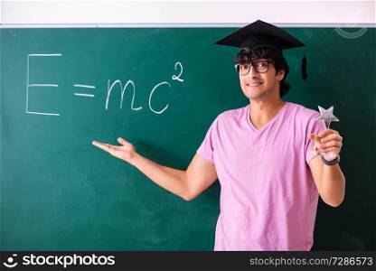 Young male physic standing in front of the green board