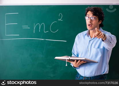 Young male physic standing in front of the green board