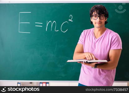 Young male physic standing in front of the green board