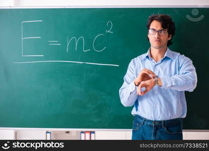 Young male physic standing in front of the green board