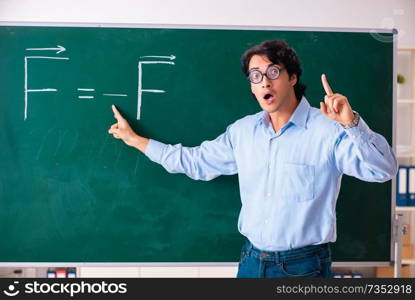 Young male physic standing in front of the green board