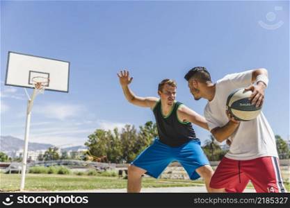 young male player playing with basketball player
