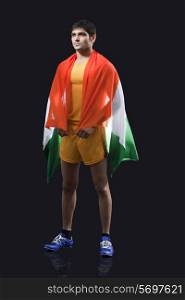 Young male runner with Indian flag standing against black background