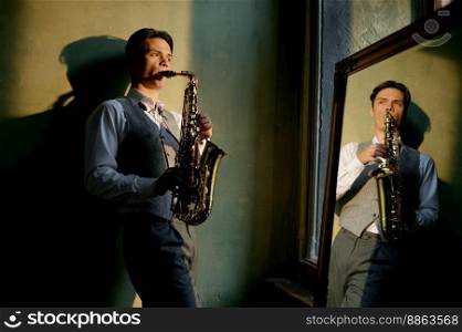 Young male saxophonist playing musical wind instrument. Artist reflection in mirror. Young male saxophonist playing musical wind instrument