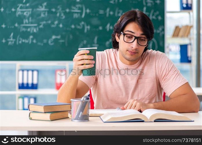 Young male student in the classroom 