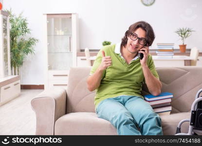 Young male student in wheelchair at home