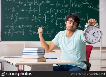 Young male student mathematician in front of chalkboard 