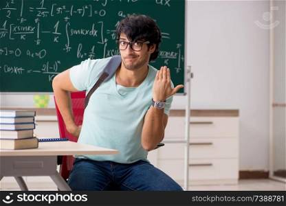 Young male student mathematician in front of chalkboard 