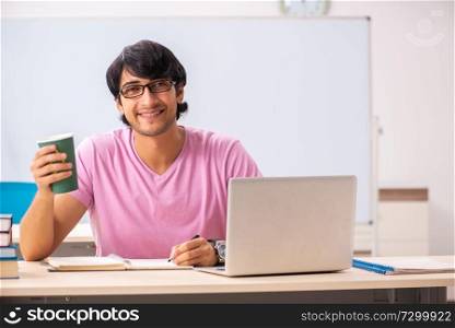 Young male student sitting in the class 
