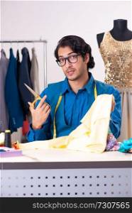 Young male tailor working at workshop 
