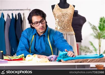 Young male tailor working at workshop 