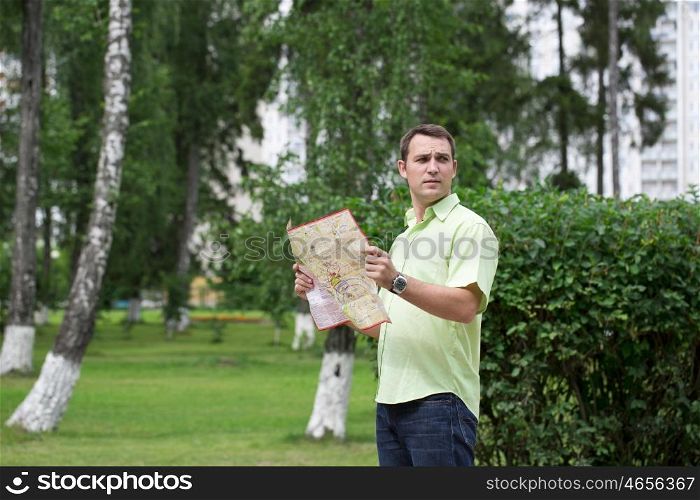 Young male tourist with map in hand looking around. Tourist map of the city of Moscow, Russia (no trademark)