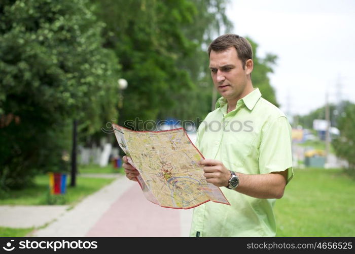 Young male tourist with map in hand looking around. Tourist map of the city of Moscow, Russia (no trademark)