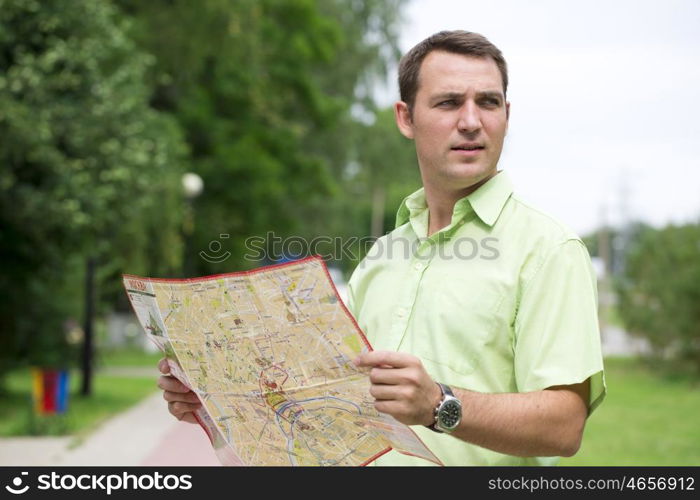 Young male tourist with map in hand looking around. Tourist map of the city of Moscow, Russia (no trademark)