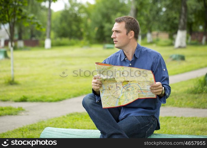 Young male tourist with map in hand looking around. Tourist map of the city of Moscow, Russia (no trademark)