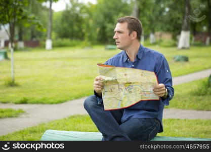 Young male tourist with map in hand looking around. Tourist map of the city of Moscow, Russia (no trademark)