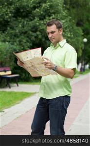Young male tourist with map in hand looking around. Tourist map of the city of Moscow, Russia (no trademark)