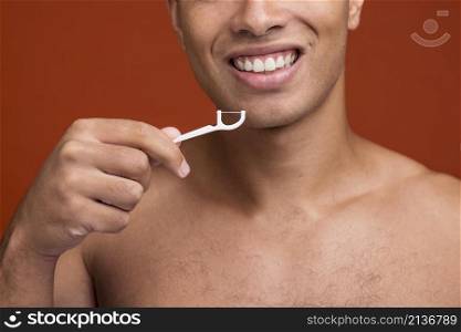 young male using dental floss