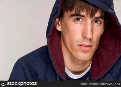 Young male wearing hooded sweatshirt.