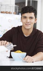 Young Man Adding Sugar To Breakfast Cereal