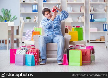 Young man after excessive shopping at home