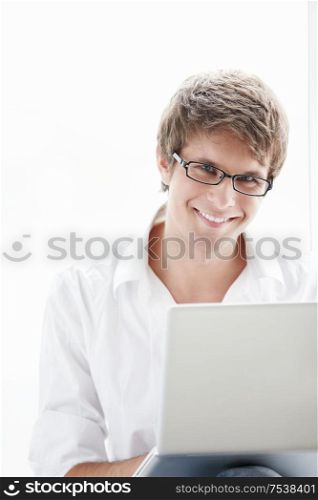 Young man against the window with a laptop