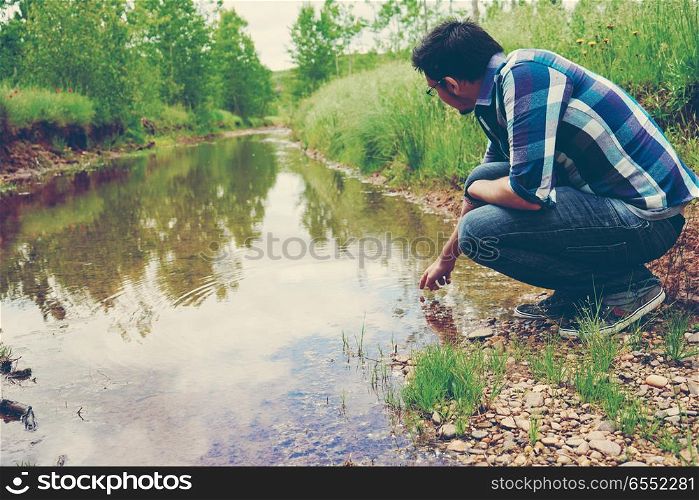 young man alone in front of a river
