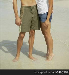 Young man and a teenage girl standing on the beach