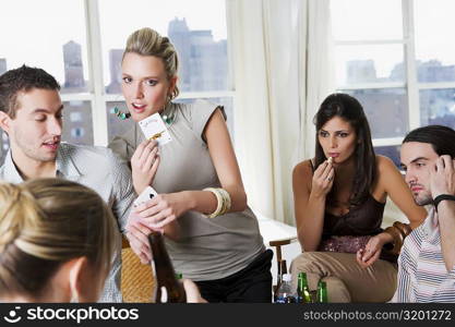 Young man and a young woman playing cards with their friends