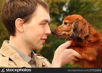 Young man and his adorable dachshund closeup