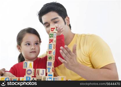 Young man and his daughter playing block game