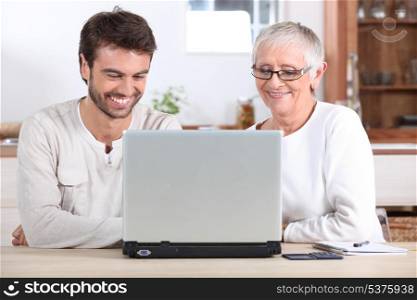 Young man and his mother using laptop