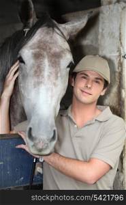 Young man and horse at a stable