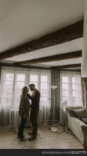 Young man and pregnant woman hugging in the room at home