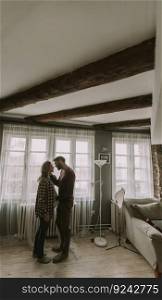 Young man and pregnant woman hugging in the room at home