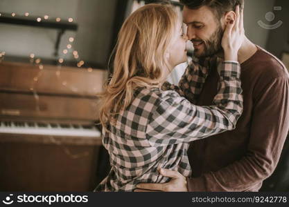 Young man and pregnant woman hugging in the room at home