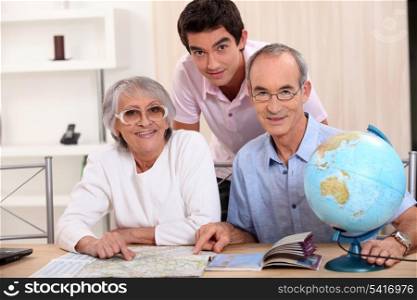 Young man and senior couple seeking a route on a map
