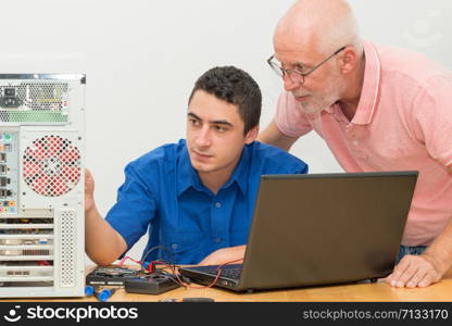 young man and senior fixing computer