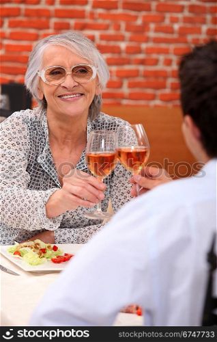 Young man and senior woman having lunch in a restaurant