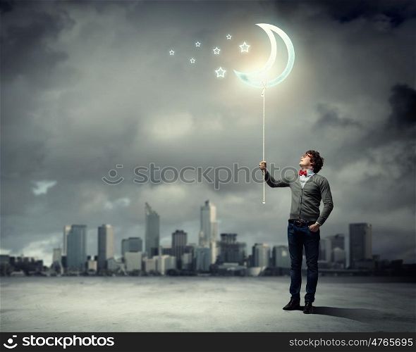 Young man and the moon symbol. Young man and the moon symbol against polluted and ruined landscape