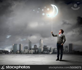 Young man and the moon symbol. Young man and the moon symbol against polluted and ruined landscape