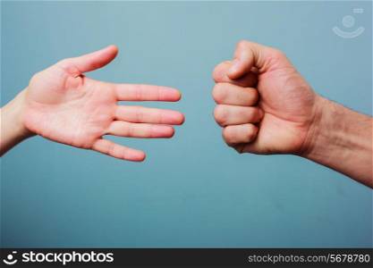Young man and woman are playing rock paper scissors